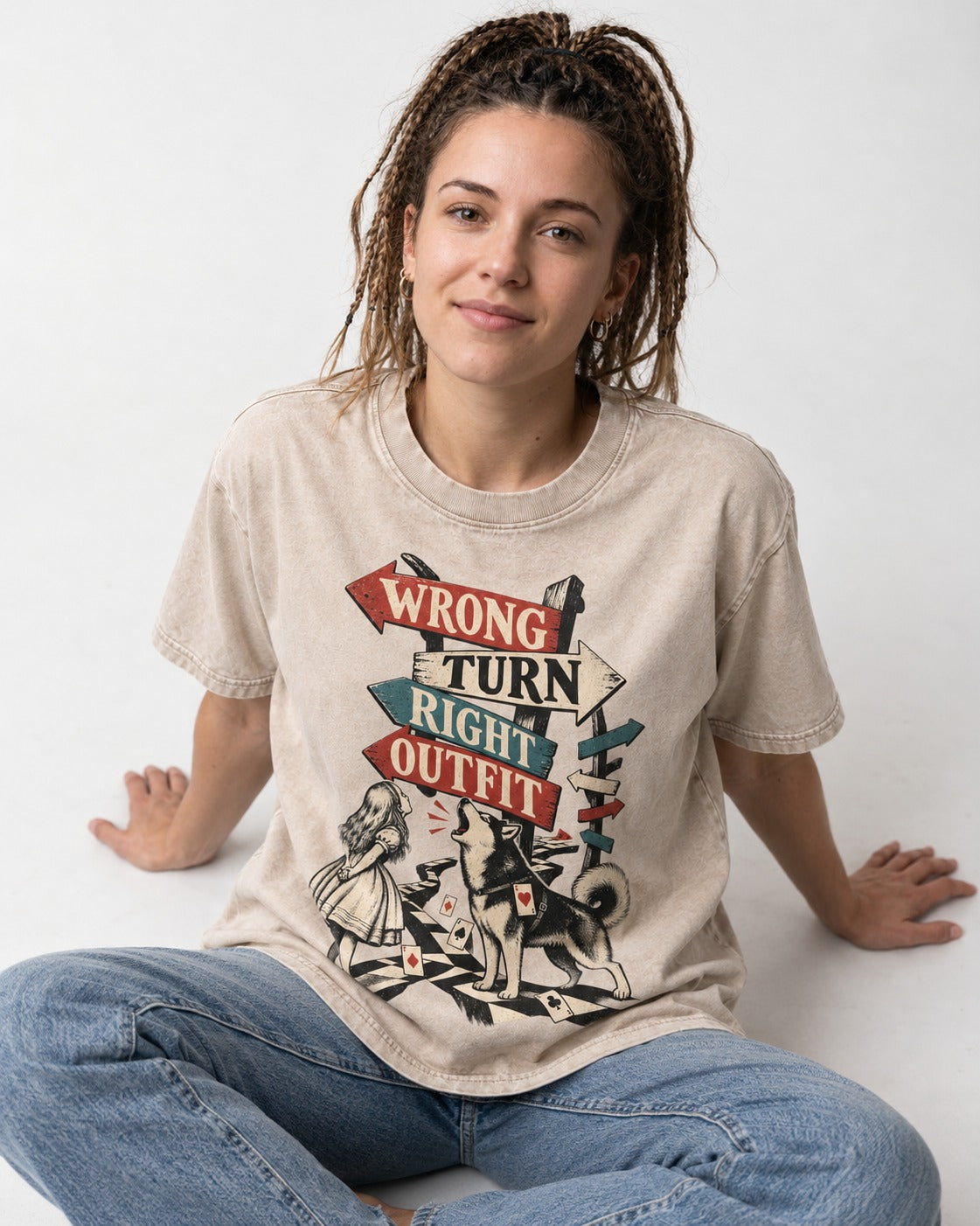 Husky Wrong Turn Right Outfit Wonderland Signpost Graphic Washed Tee in Apricot, worn by a seated model