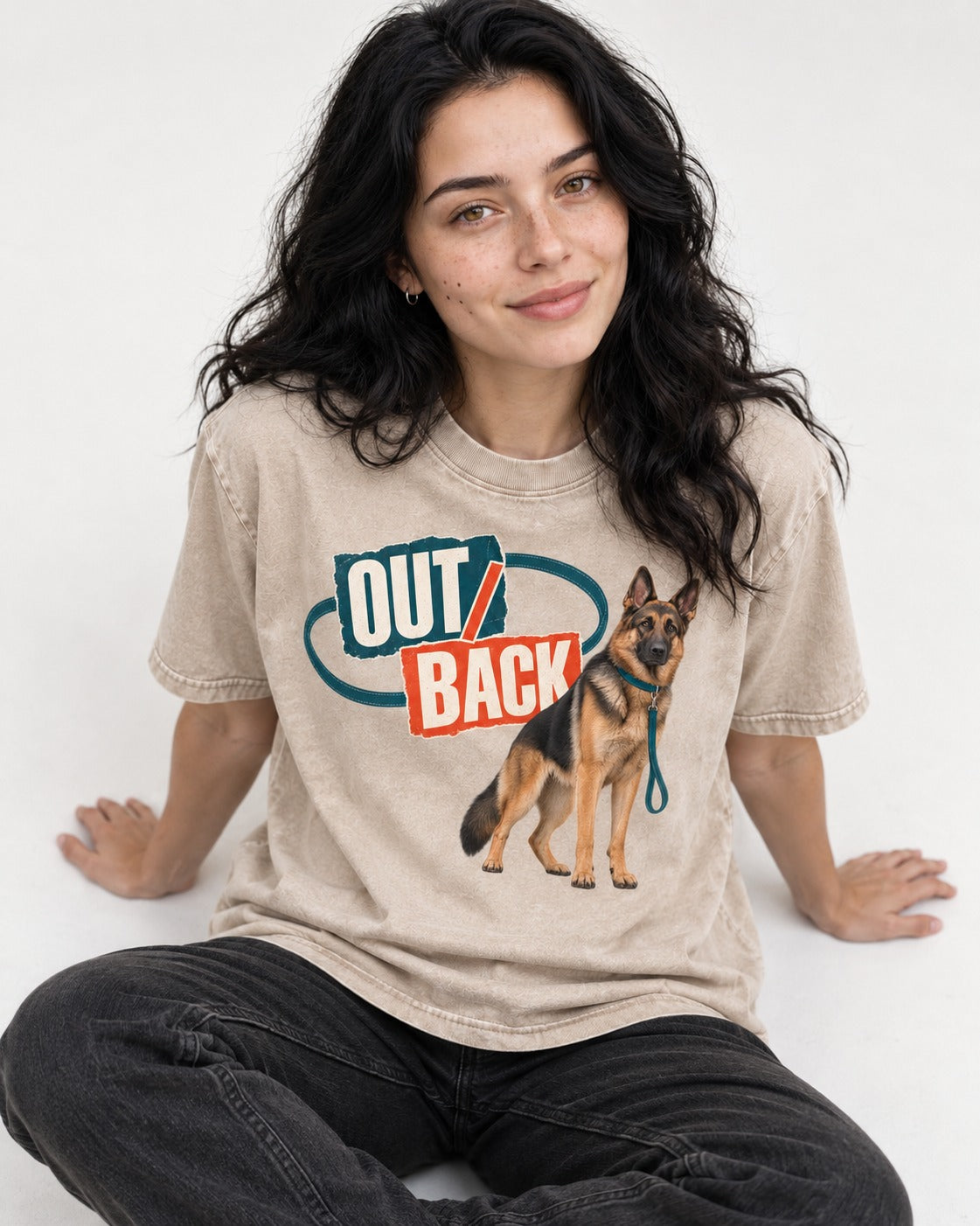 Out Back Leash German Shepherd Dog Graphic Washed Tee in Apricot, worn by a seated model