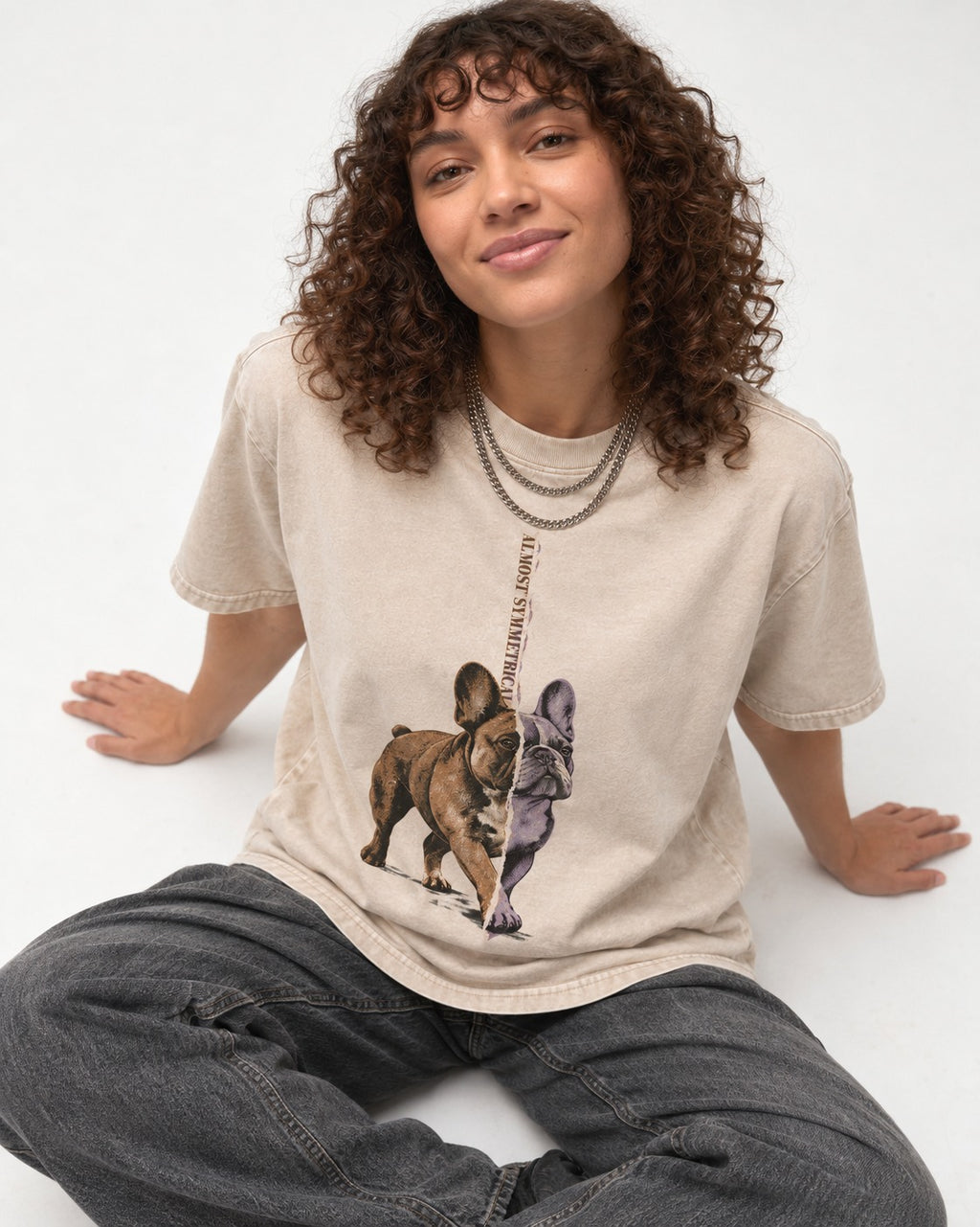 Frenchie Almost Symmetrical Torn Split Graphic Washed Tee in Apricot, worn by a seated model