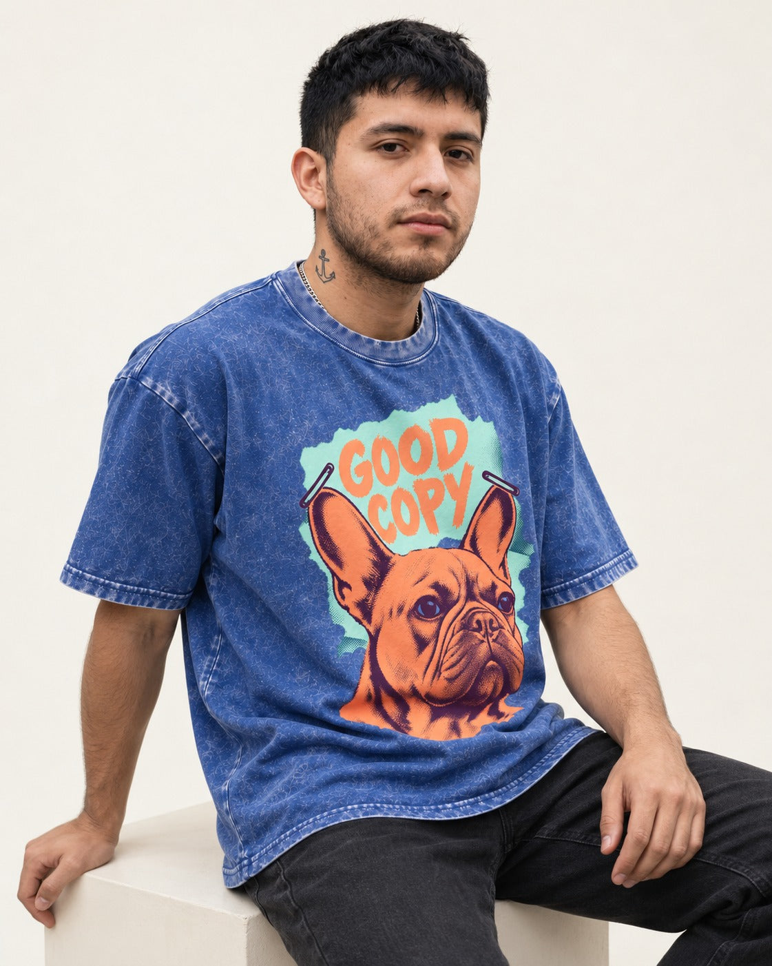 Frenchie Good Copy Stapled Zine Graphic Washed Tee in Royal Blue, worn by a seated model