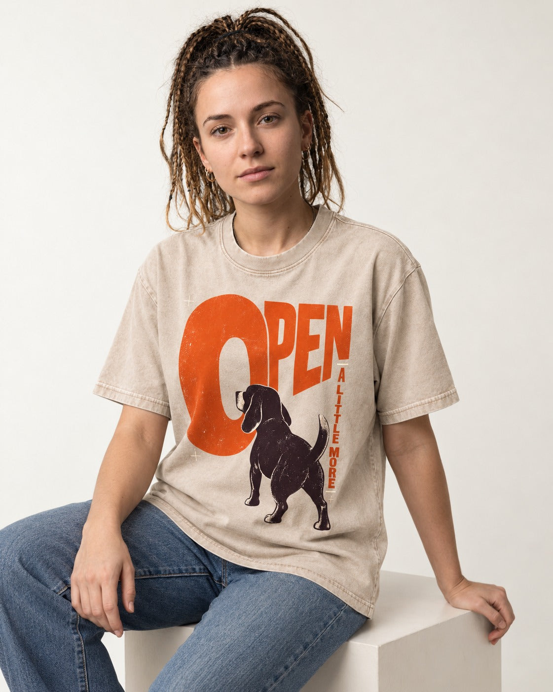 Open a Little More Beagle Washed Tee in Apricot, worn by a seated model