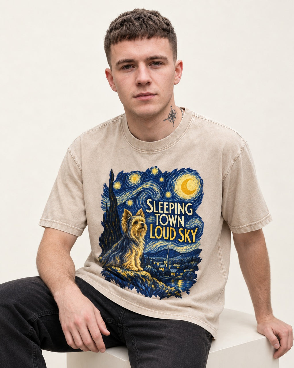 Yorkshire Terrier Sleeping Town Loud Sky Starry Night Graphic Washed Tee in Apricot, worn by a seated model