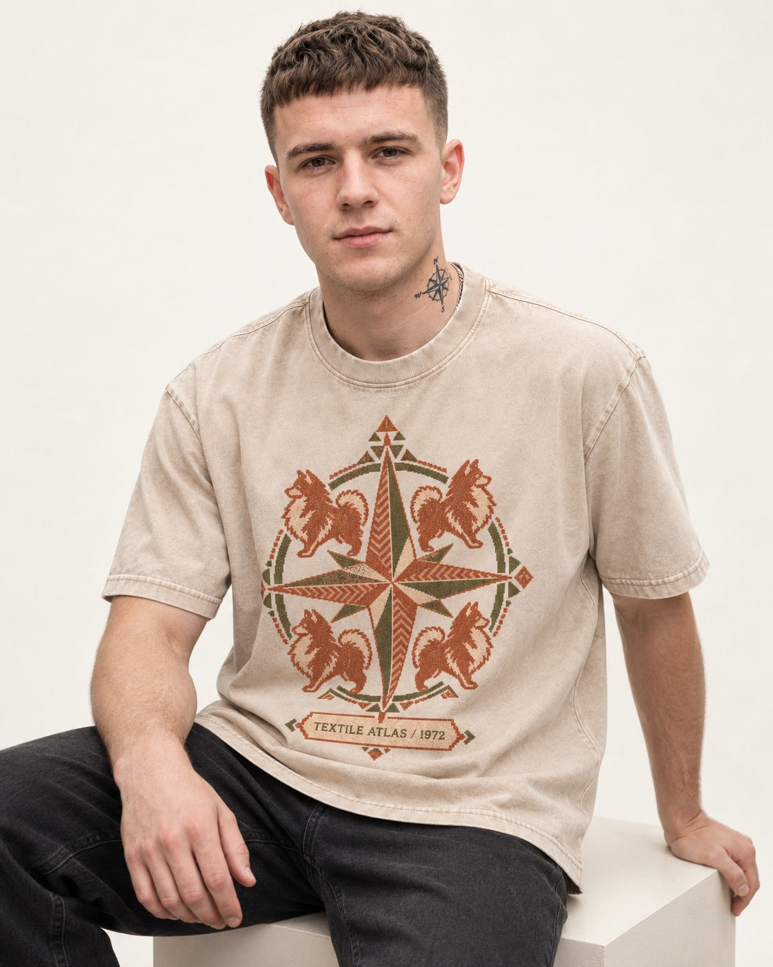 Pomeranian Textile Atlas Compass Rose Graphic Washed Tee in Apricot, worn by a seated model