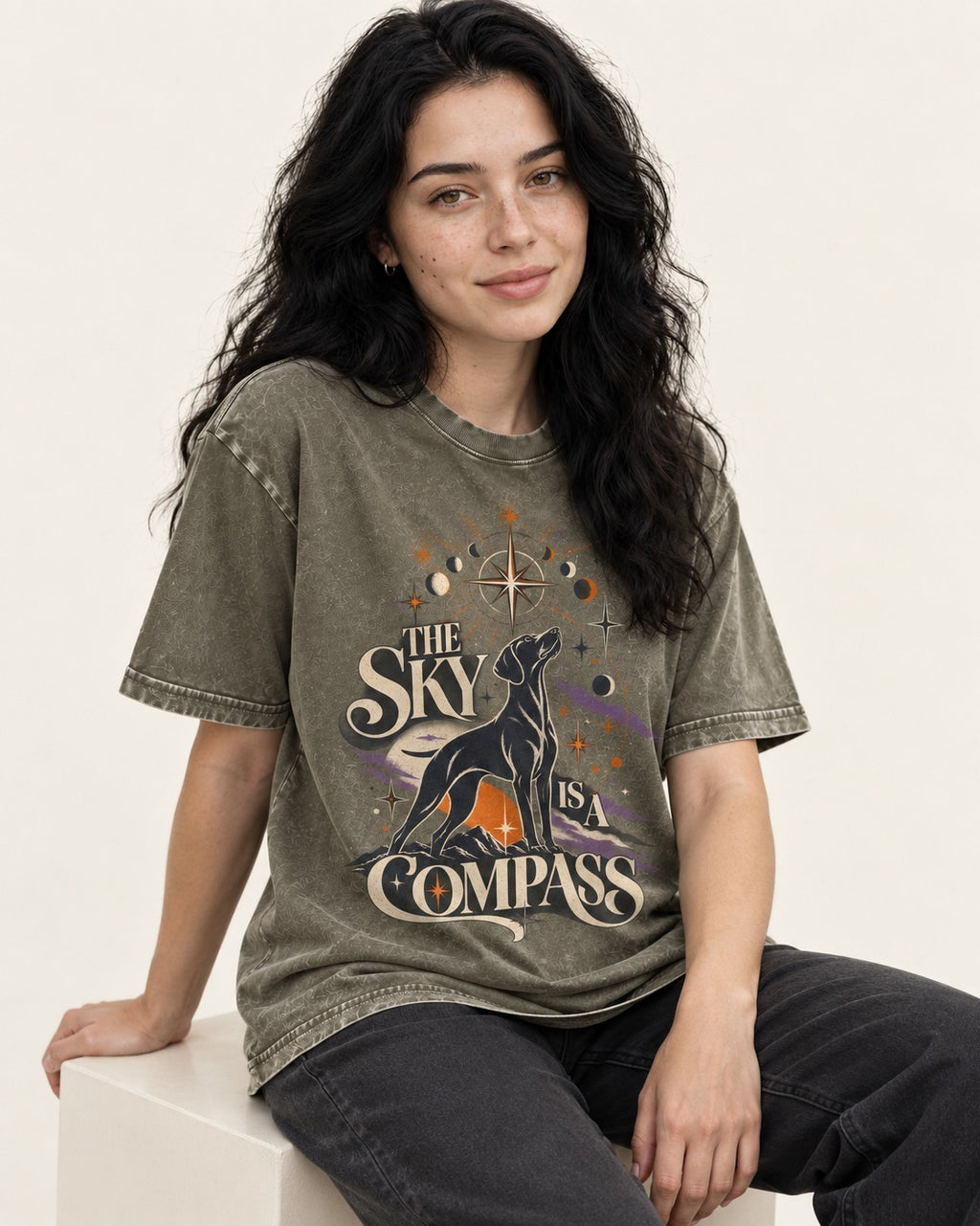 The Sky Is a Compass Celestial German Shorthaired Pointer Graphic Washed Tee in Army Green, worn by a seated model