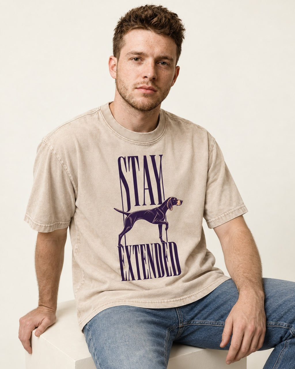Stay Extended German Shorthaired Pointer Washed Tee in Apricot, worn by a seated model