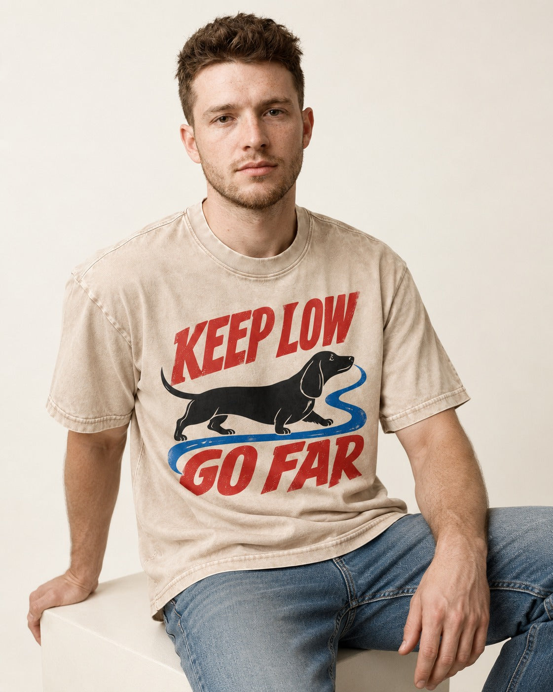 Keep Low Go Far Dachshund Washed Tee in Apricot, worn by a seated model