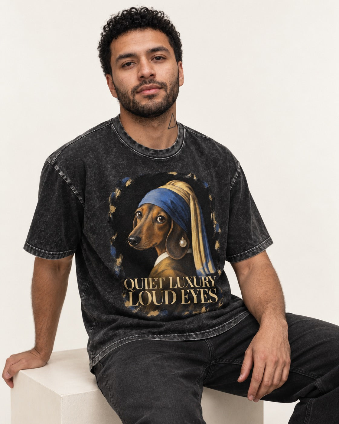 Dachshund Quiet Luxury Loud Eyes Pearl Portrait Graphic Washed Tee in Black, worn by a seated model