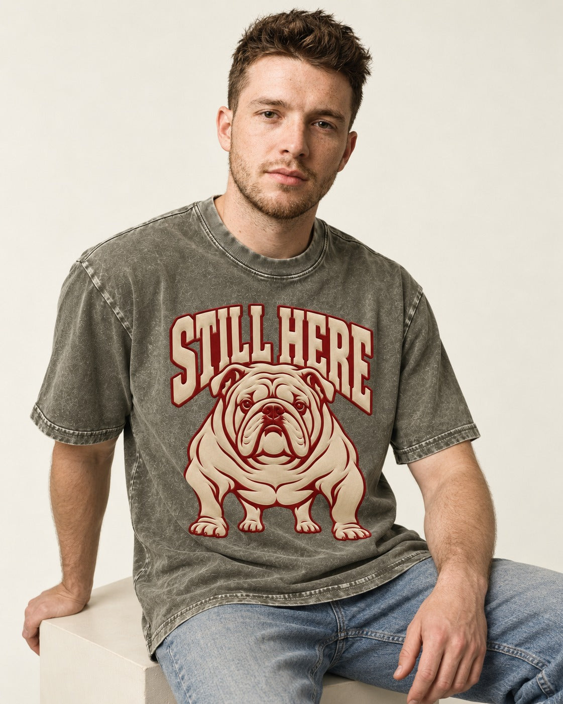 English Bulldog Still Here Collegiate Graphic Washed Tee in Army Green, worn by a seated model