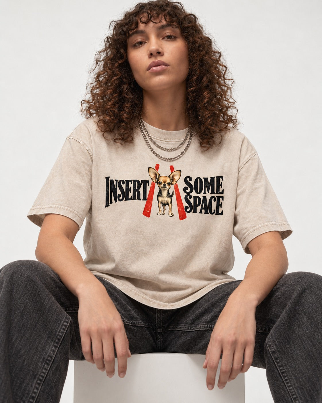 Insert Some Chihuahua Space Washed Tee in Apricot, worn by a seated model