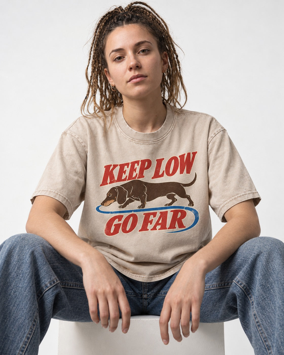 Dachshund Keep Low Go Far Washed Tee in Apricot, worn by a seated model