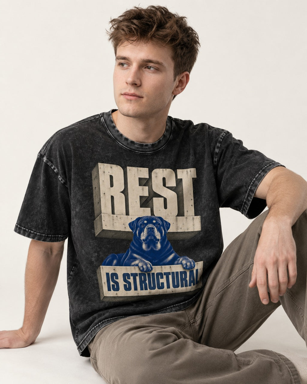 Rottweiler Rest Is Structural Architectural Type Graphic Washed Tee in Black, worn by a seated model