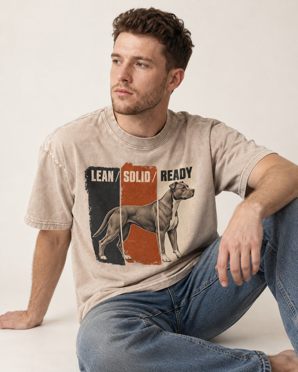 Pitbull Lean Solid Ready Triptych Graphic Washed Tee in Apricot, worn by a seated model