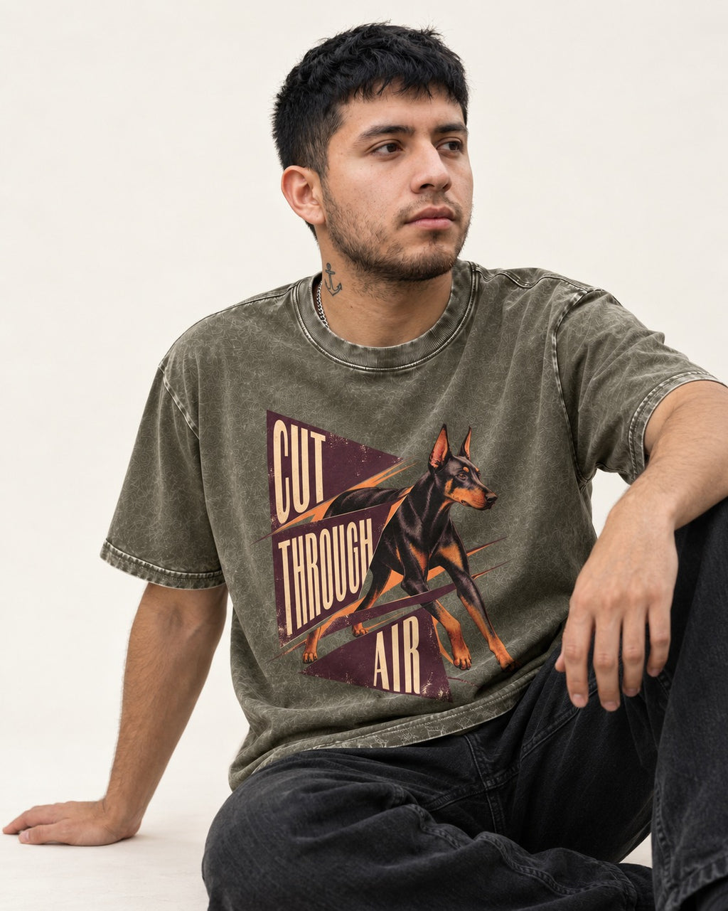 Doberman Cut Through Air Graphic Washed Tee in Army Green, worn by a seated model