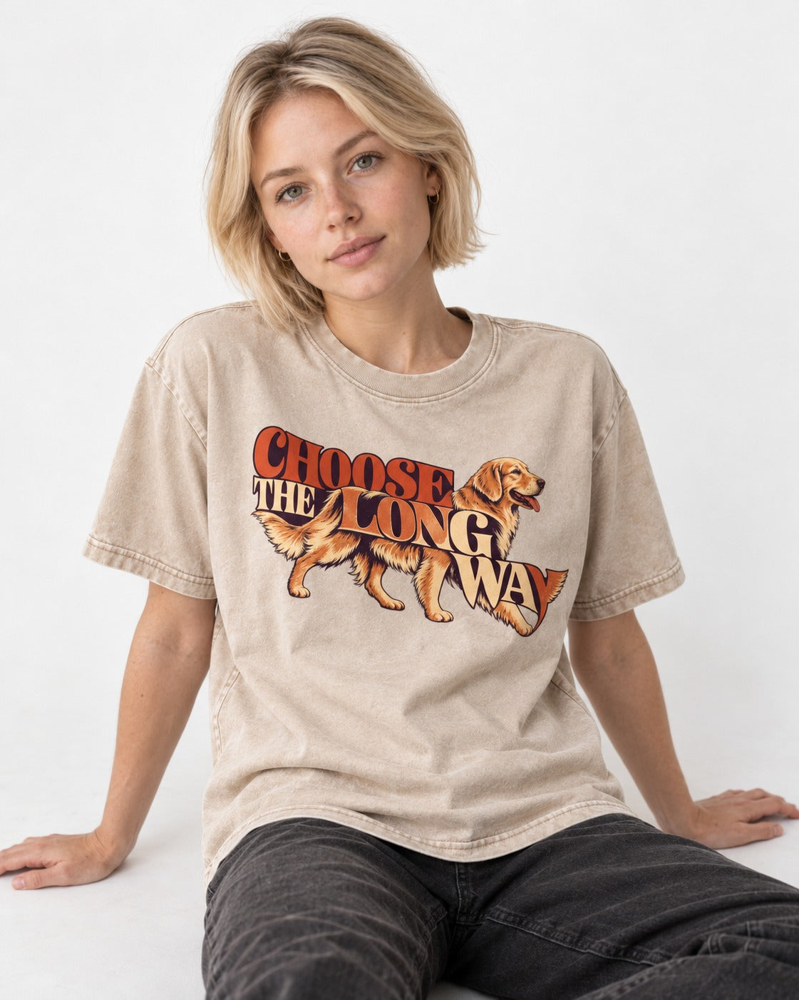 Golden Retriever Choose The Long Way Retro Graphic Washed Tee in Apricot, worn by a seated model