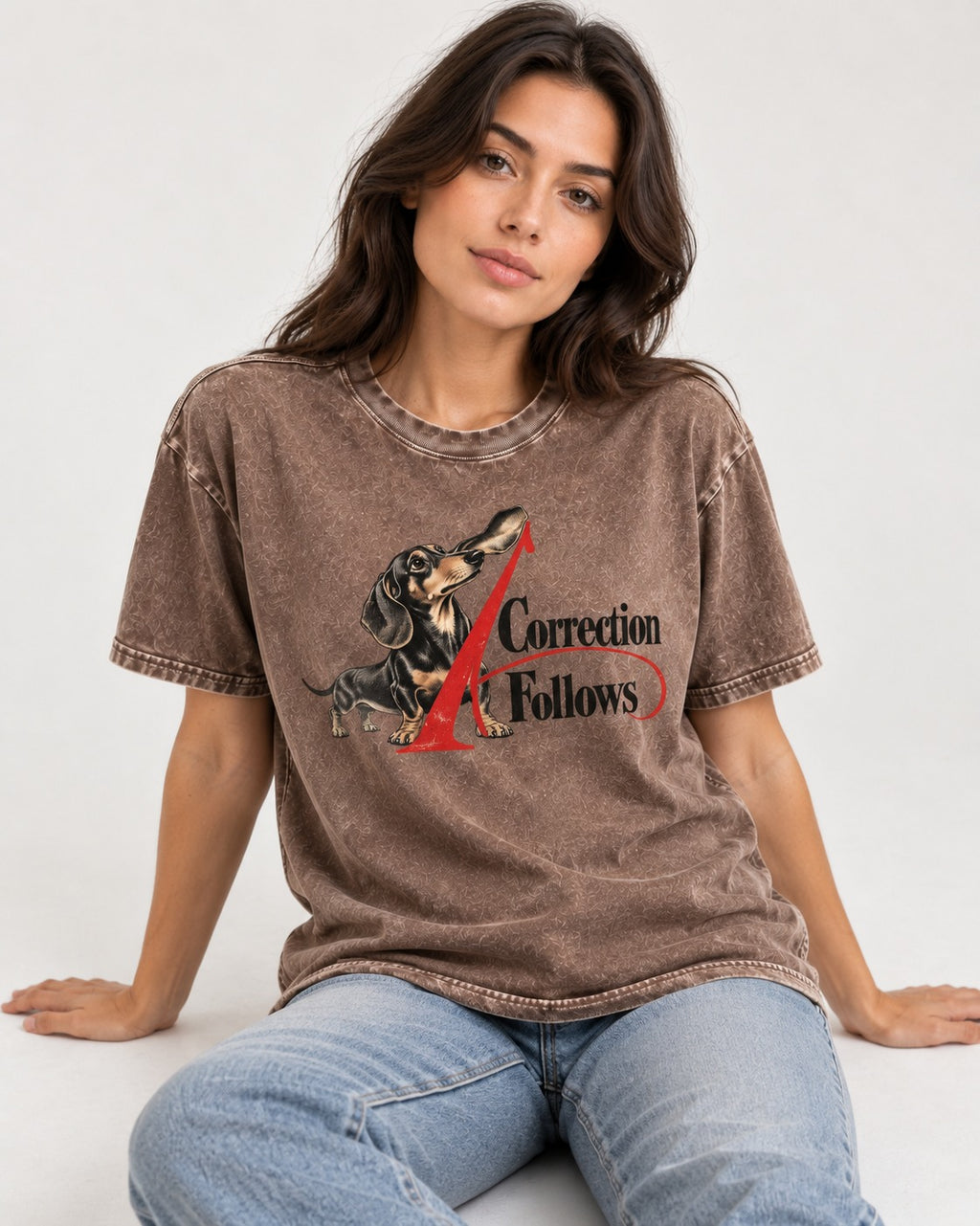 A Dachshund Correction Follows Washed Tee in Coffee, worn by a seated model