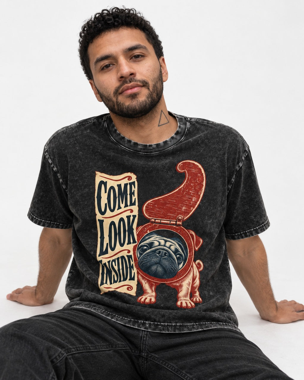 Pug Come Look Inside Toilet Seat Graphic Washed Tee in Black, worn by a seated model