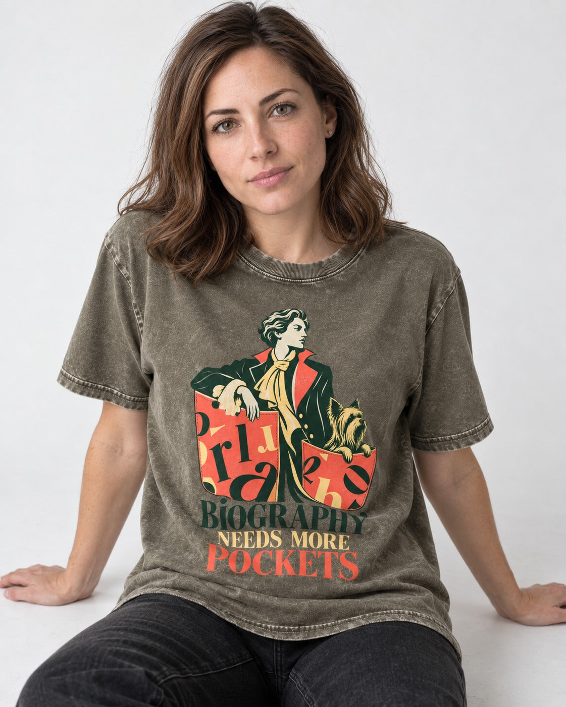 Yorkshire Terrier Biography Needs More Pockets Literary Portrait Graphic Washed Tee in Army Green, worn by a seated model