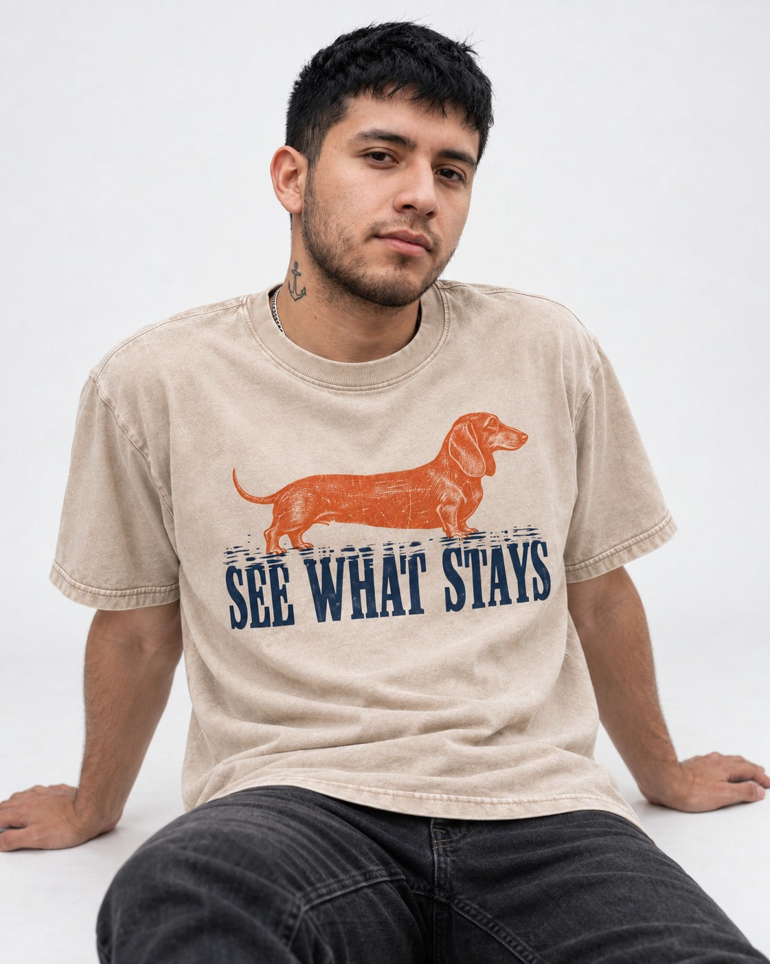 Dachshund See What Stays Washed Tee in Apricot, worn by a seated model