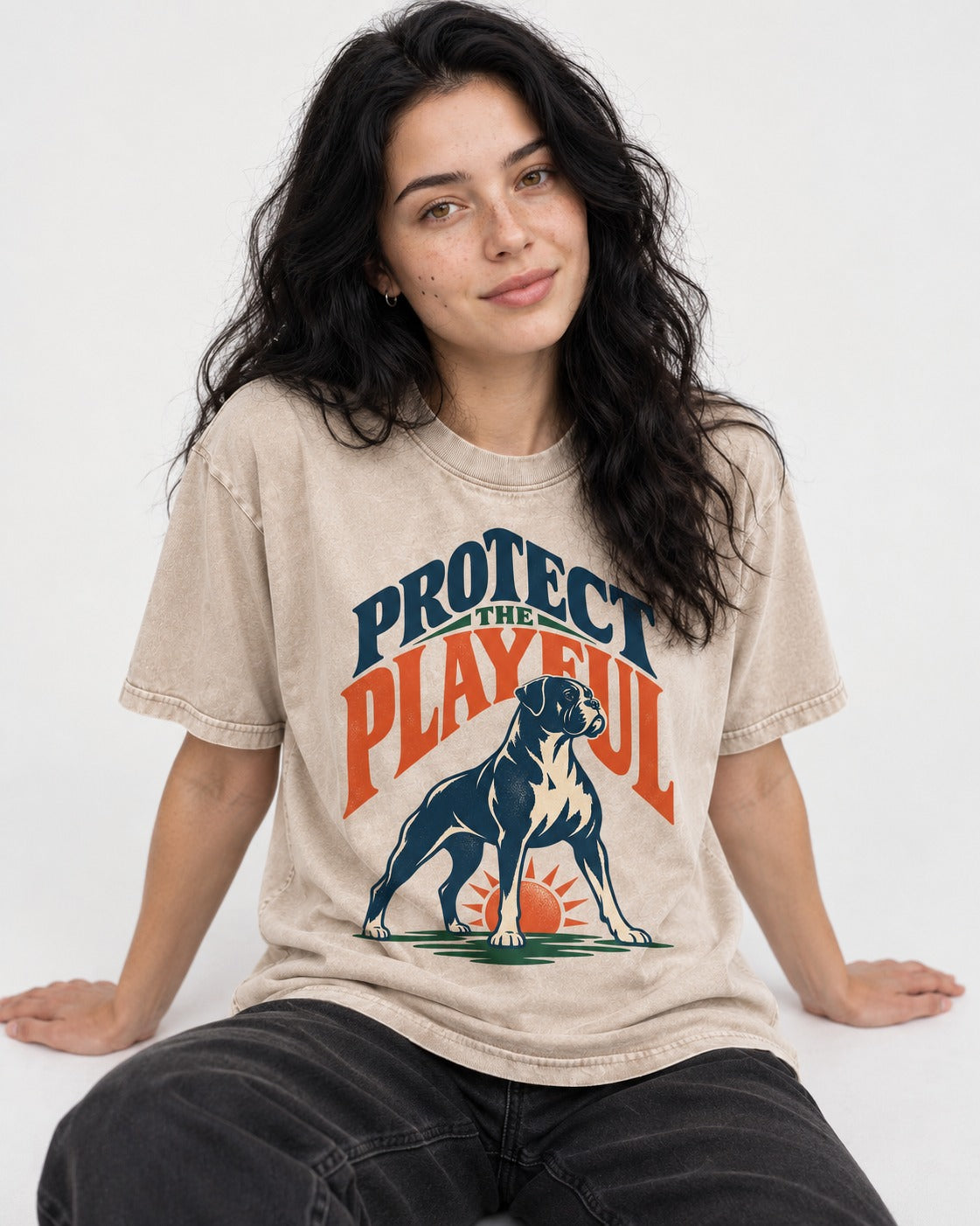 Protect the Playful Boxer Washed Tee in Apricot, worn by a seated model