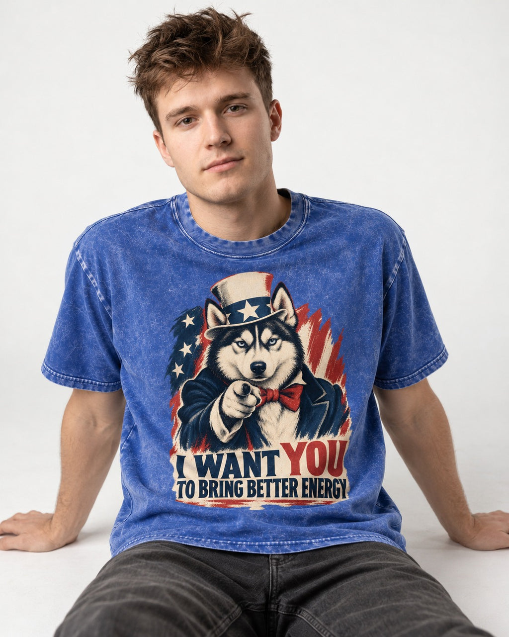 Husky I Want You to Bring Better Energy Patriotic Poster Graphic Washed Tee in Royal Blue, worn by a seated model