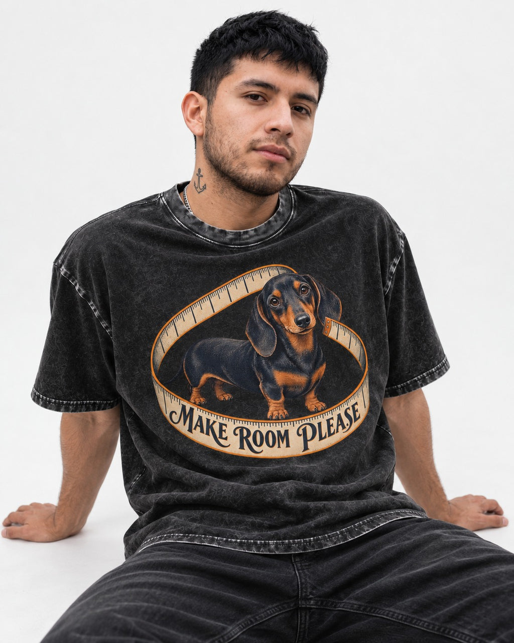 Dachshund Make Room Please Measuring Tape Graphic Washed Tee in Black, worn by a seated model