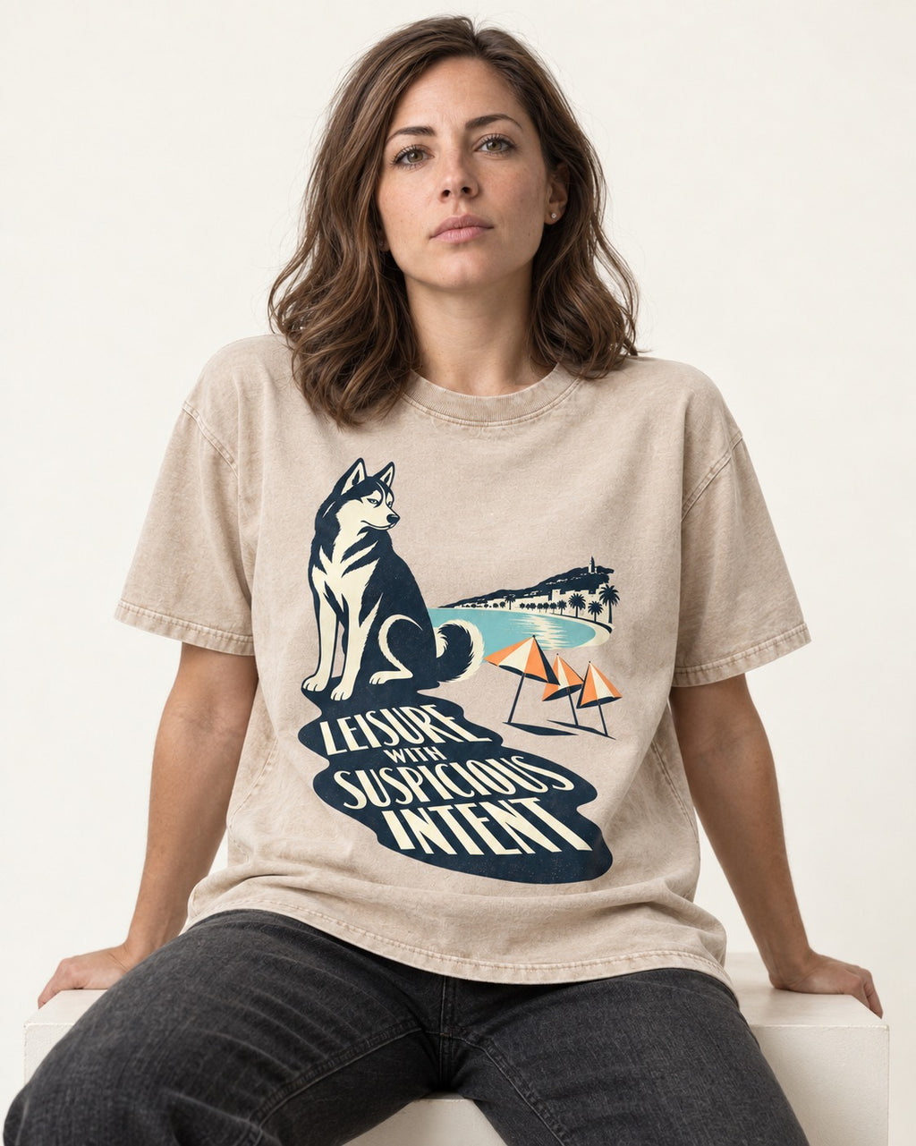 Husky Leisure with Suspicious Intent Washed Tee in Apricot, worn by a seated model