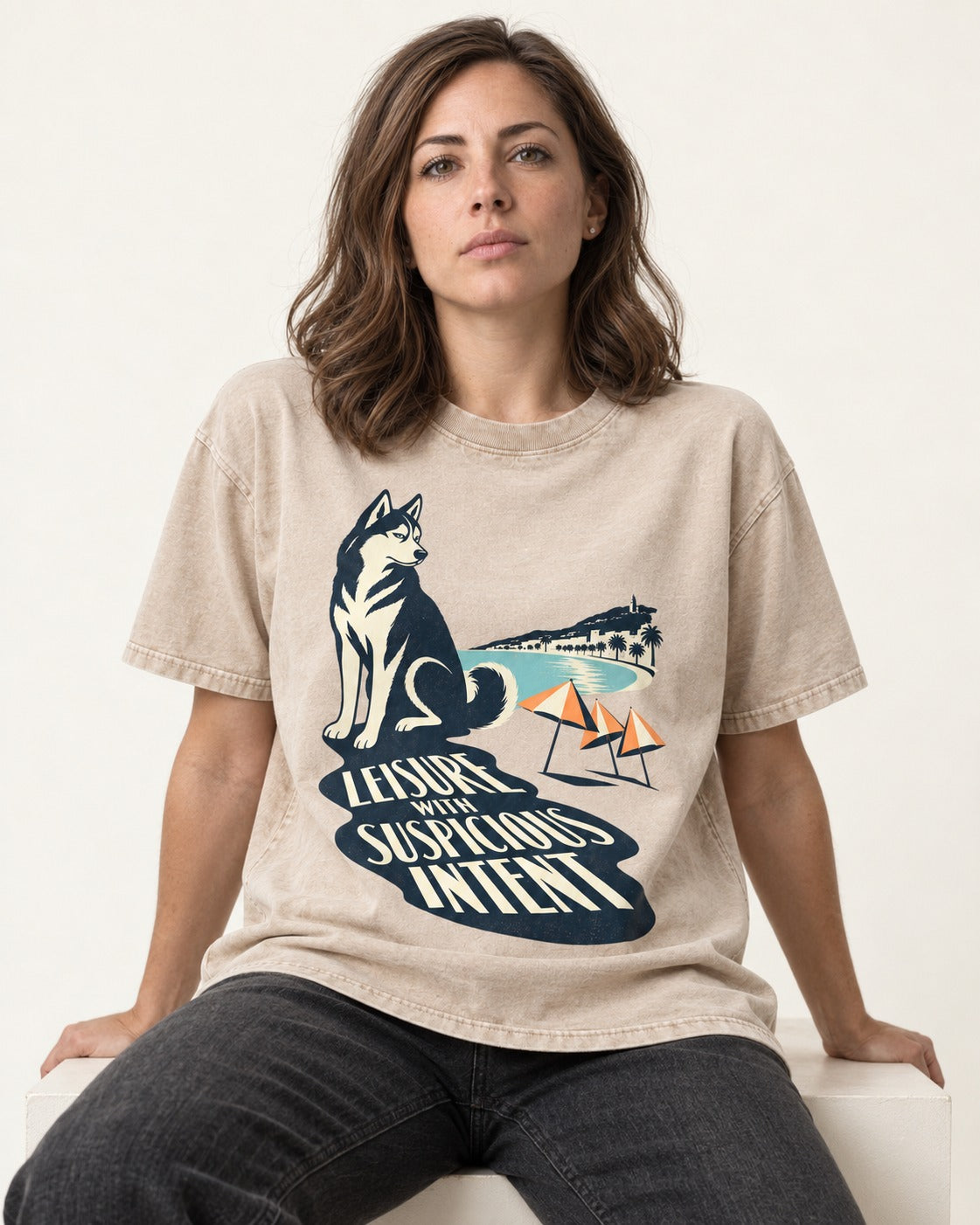 Husky Leisure with Suspicious Intent Washed Tee in Apricot, worn by a seated model