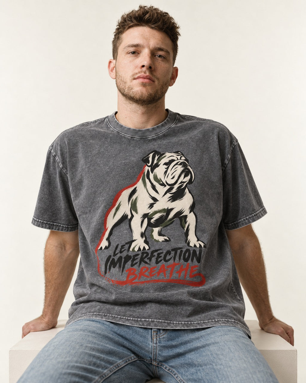 Let Imperfection Breathe English Bulldog Washed Tee in Gray, worn by a seated model