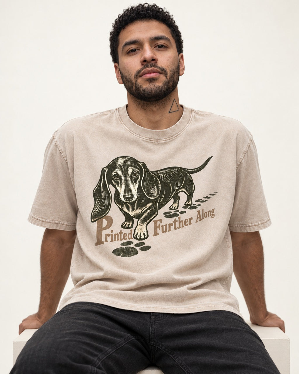 Dachshund Printed Further Along Footprint Graphic Washed Tee in Apricot, worn by a seated model