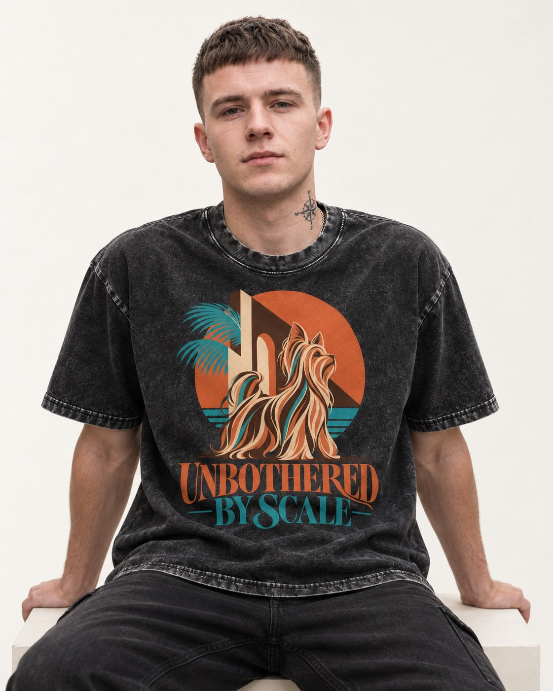 Yorkshire Terrier Unbothered by Scale Tropical Architecture Graphic Washed Tee in Black, worn by a seated model