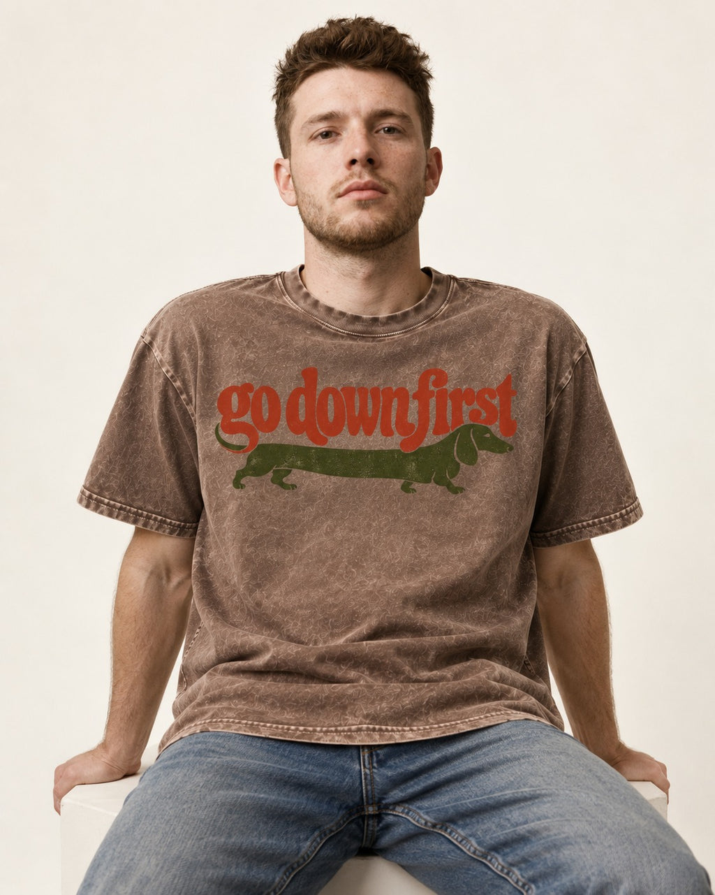 Dachshund Goes Down First Washed Tee in Coffee, worn by a seated model