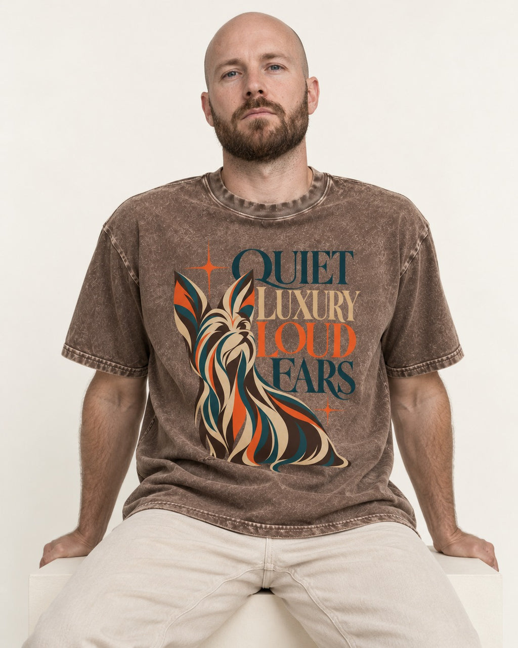 Quiet Luxury Loud Ears Yorkshire Terrier Washed Tee in Coffee, worn by a seated model