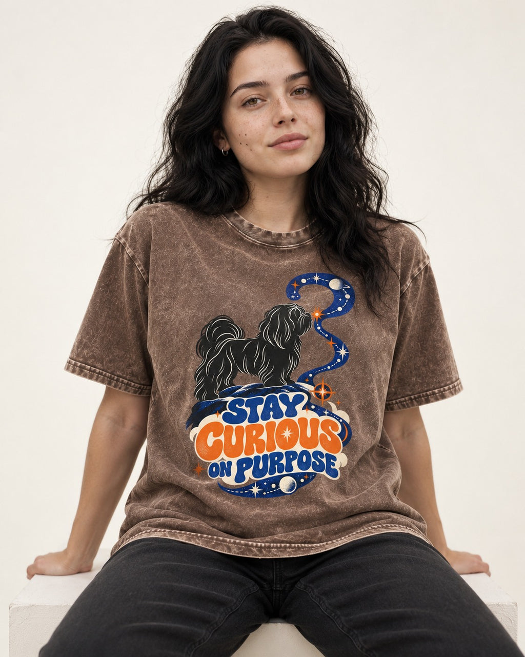 Stay Curious on Purpose Shih Tzu Washed Tee in Coffee, worn by a seated model
