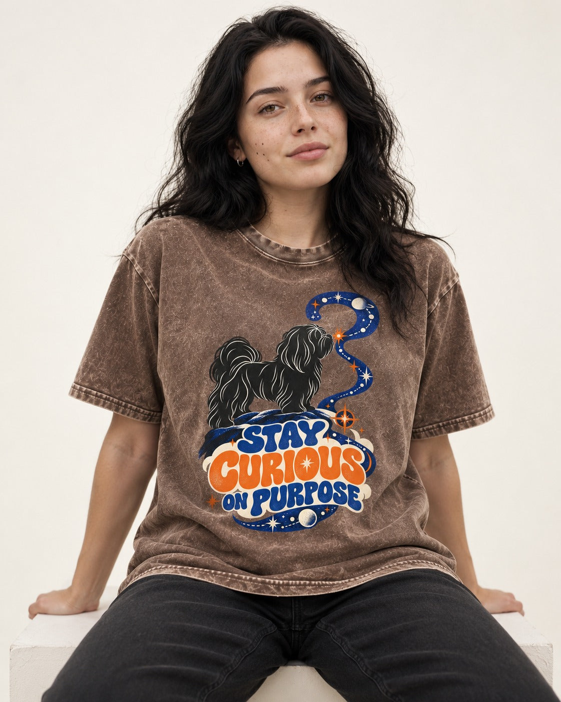 Stay Curious on Purpose Shih Tzu Washed Tee in Coffee, worn by a seated model