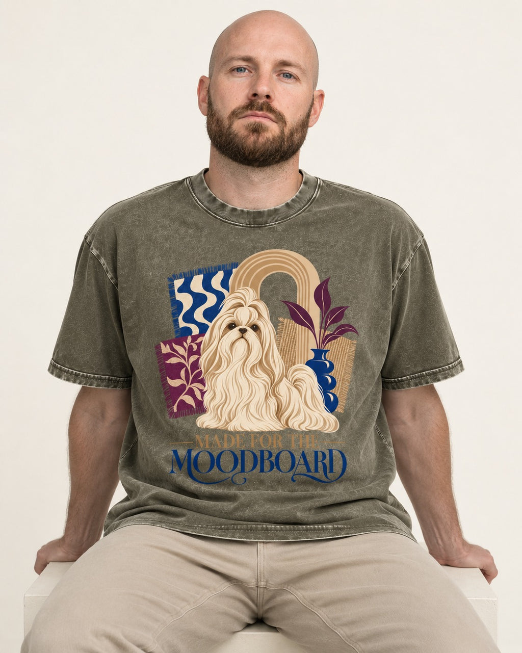 Shih Tzu Made for the Moodboard Boho Interior Graphic Washed Tee in Army Green, worn by a seated model
