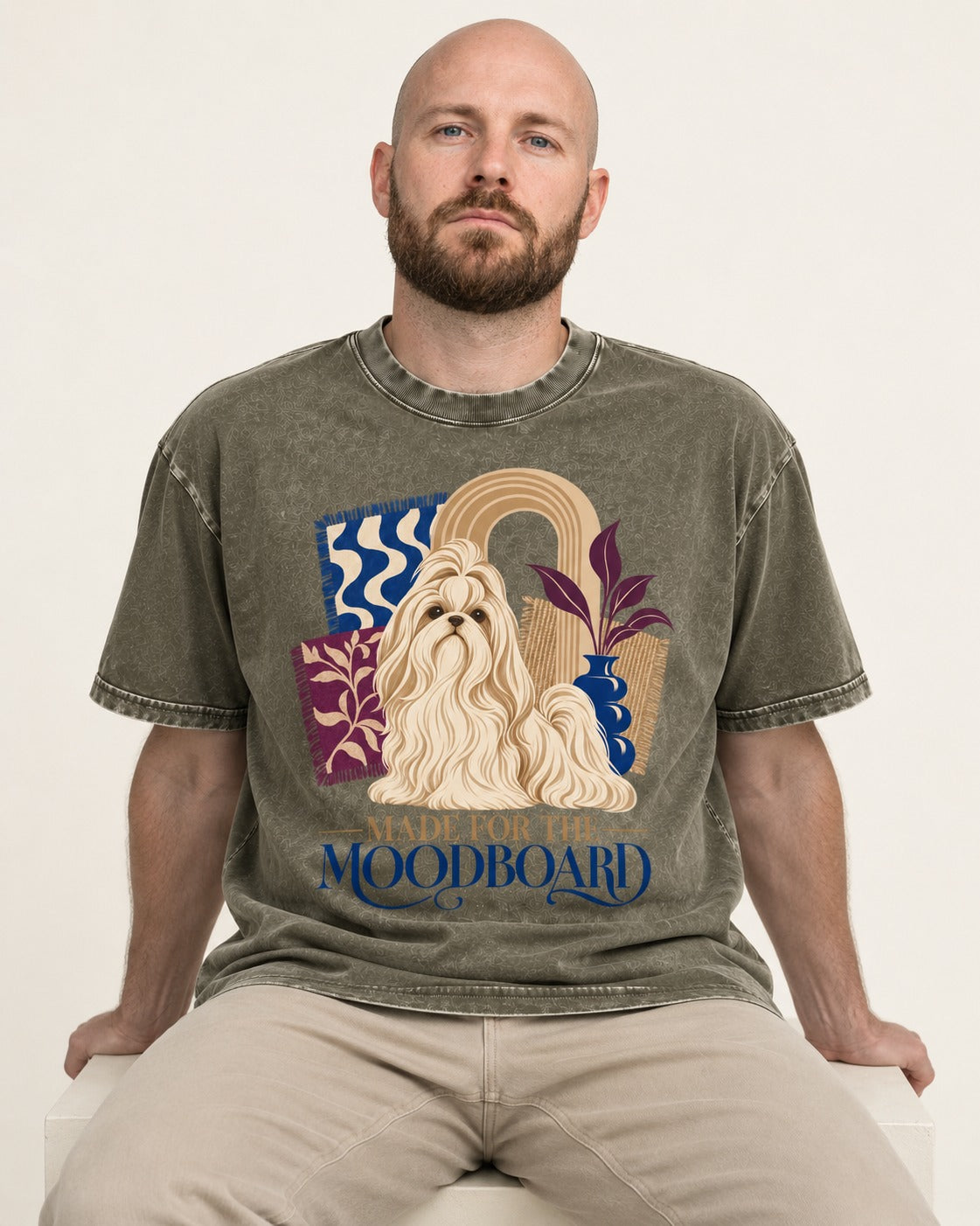 Shih Tzu Made for the Moodboard Boho Interior Graphic Washed Tee in Army Green, worn by a seated model