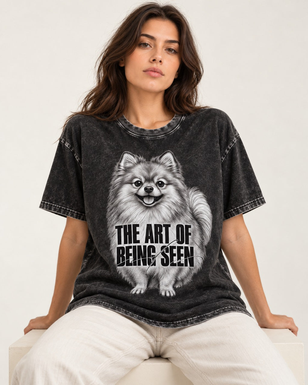 Pomeranian The Art of Being Seen Portrait Graphic Washed Tee in Black, worn by a seated model