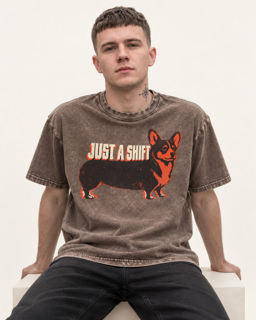 Corgi Just a Shift Typographic Graphic Washed Tee in Coffee, worn by a seated model