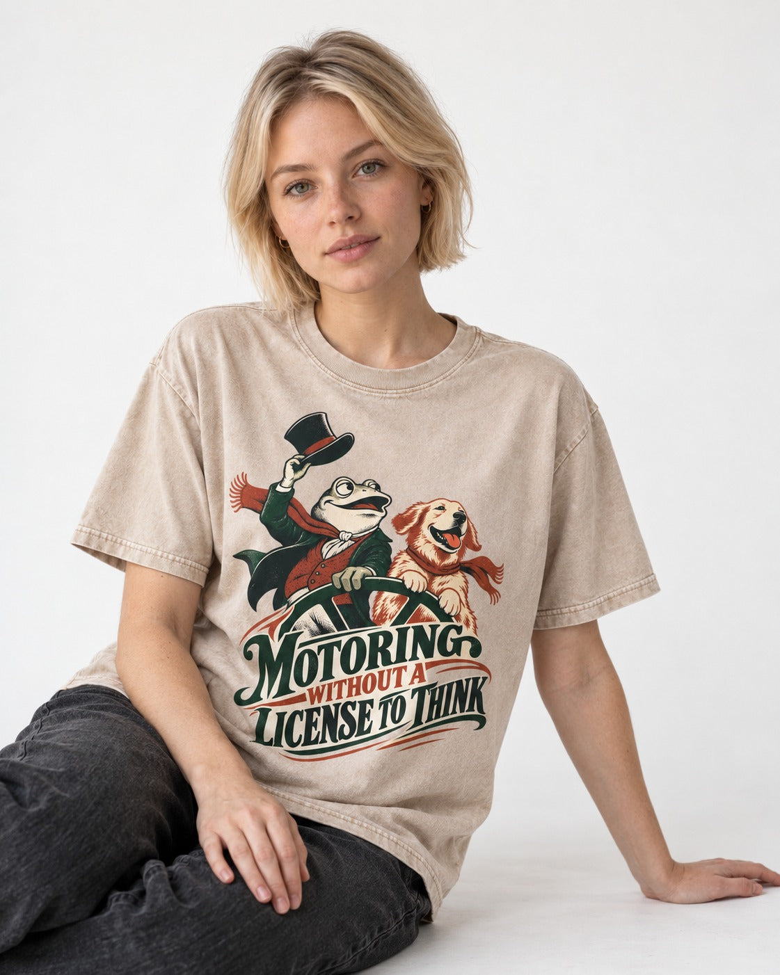 Golden Retriever Motoring Without a License to Think Driving Graphic Washed Tee in Apricot, worn by a seated model