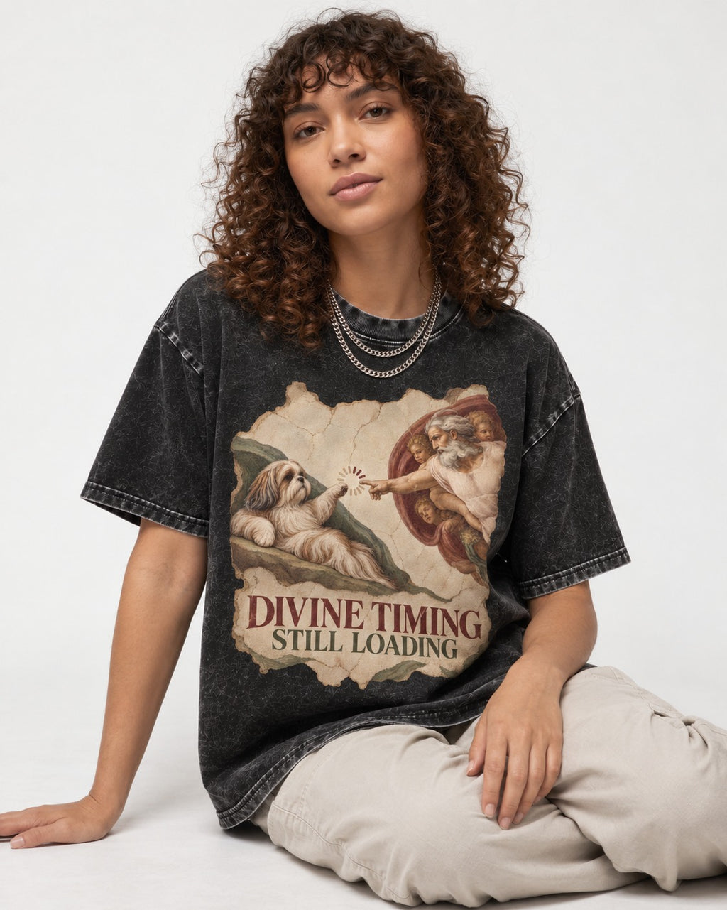 Shih Tzu Divine Timing Still Loading Renaissance Parody Graphic Washed Tee in Black, worn by a seated model