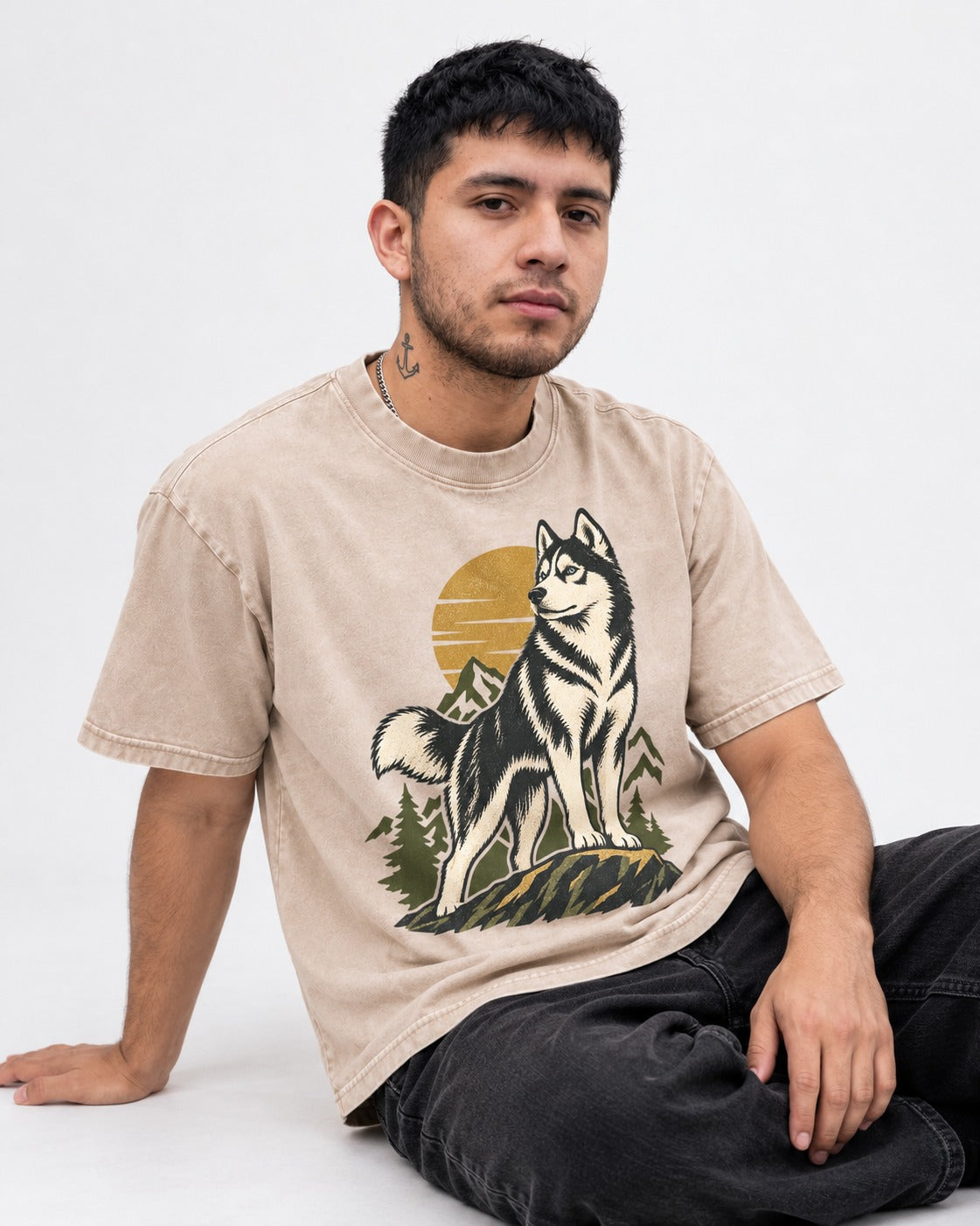 Husky Born to Roam Washed Tee in Apricot, worn by a seated model