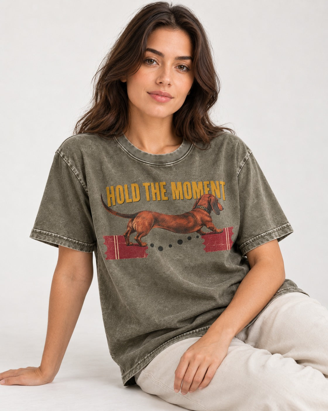 Dachshund Hold The Moment Torn Ticket Bridge Graphic Washed Tee in Army Green, worn by a seated model