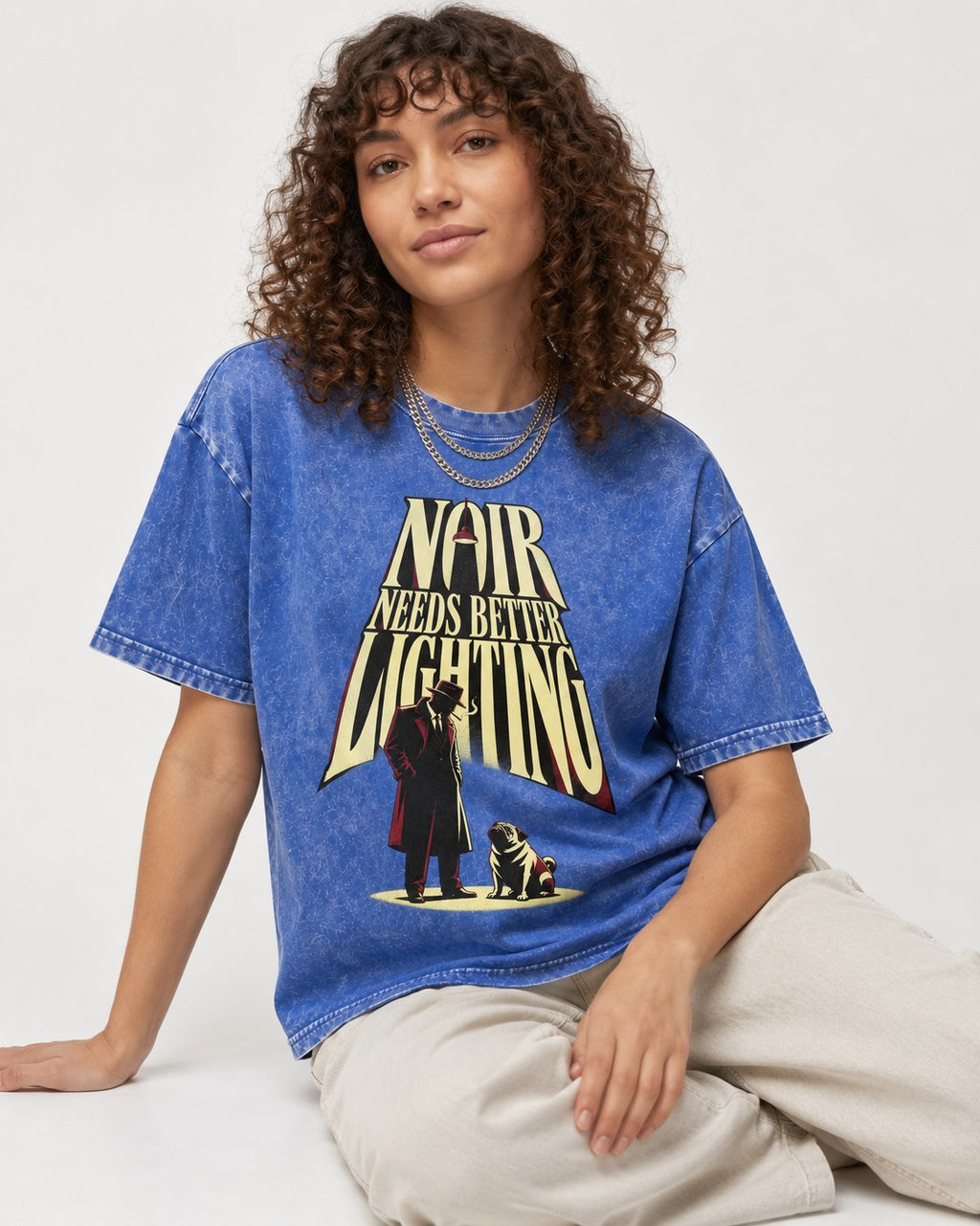 Pug Noir Needs Better Lighting Detective Graphic Washed Tee in Royal Blue, worn by a seated model