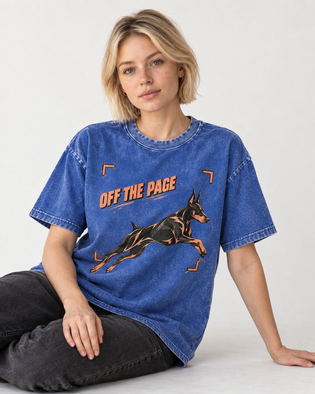 Doberman Off the Page Focus Frame Graphic Washed Tee in Royal Blue, worn by a seated model