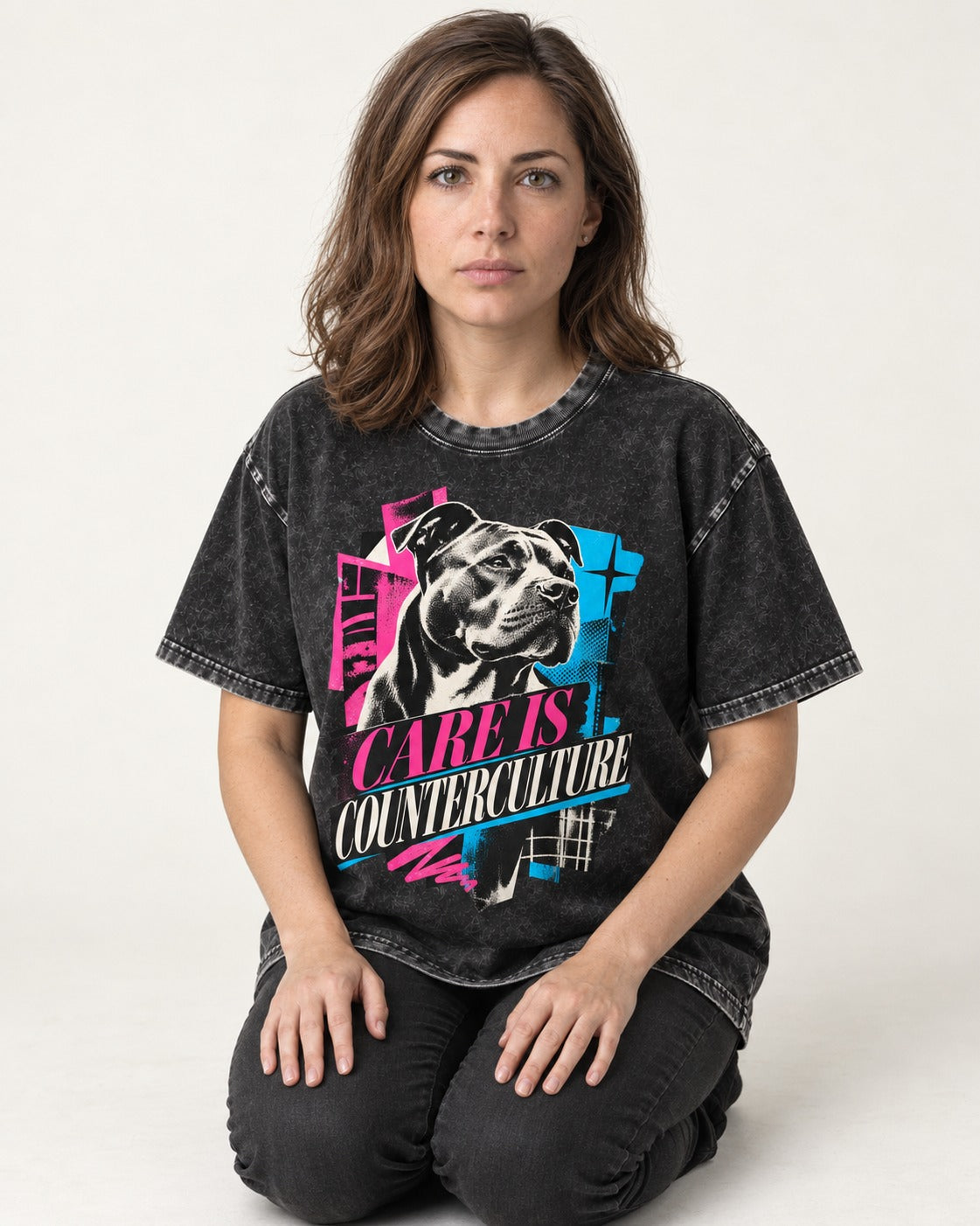 Pitbull Care Is Counterculture Neon Collage Portrait Graphic Washed Tee in Black, worn by a seated model