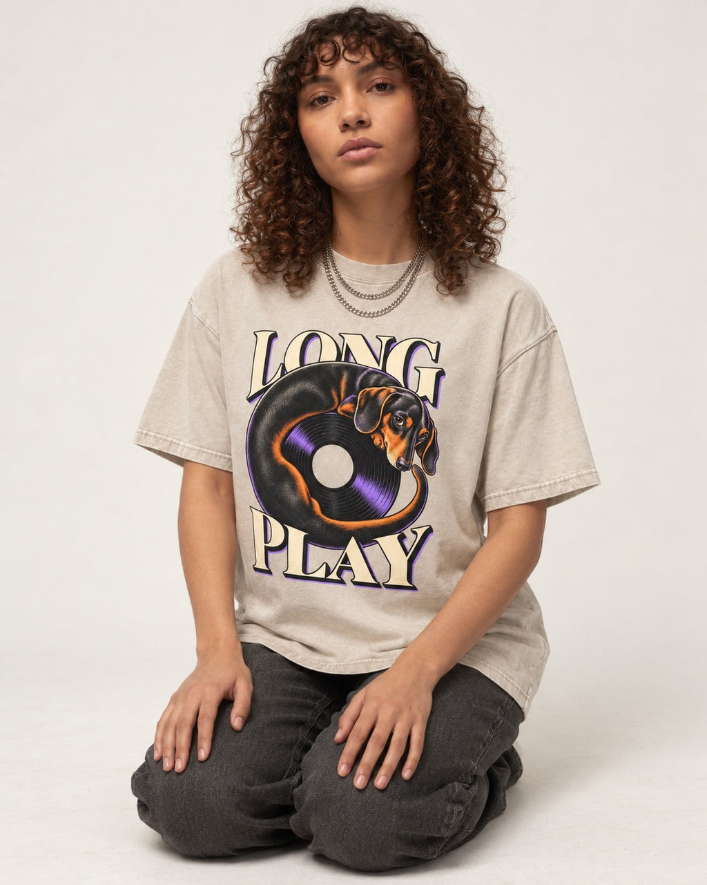 Dachshund Long Play Vinyl Record Graphic Washed Tee in Apricot, worn by a seated model