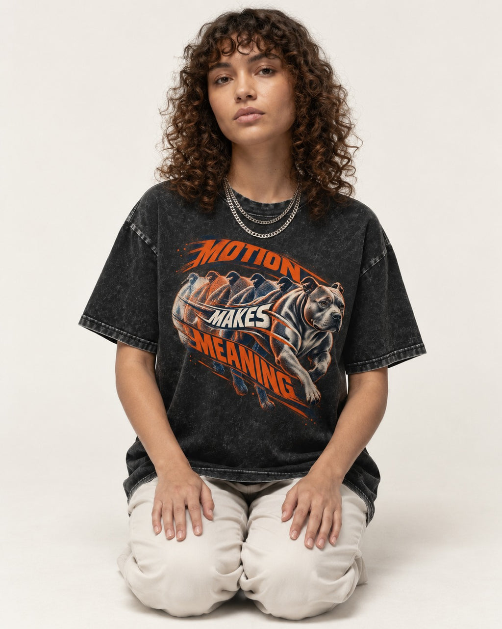 Pitbull Motion Makes Meaning Running Dog Graphic Washed Tee in Black, worn by a seated model