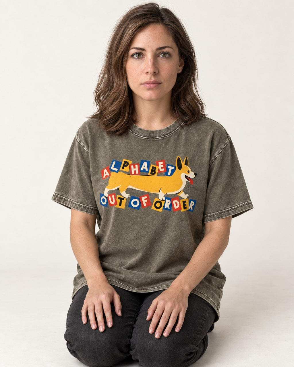 Corgi Alphabet Out of Order Graphic Washed Tee in Army Green, worn by a seated model