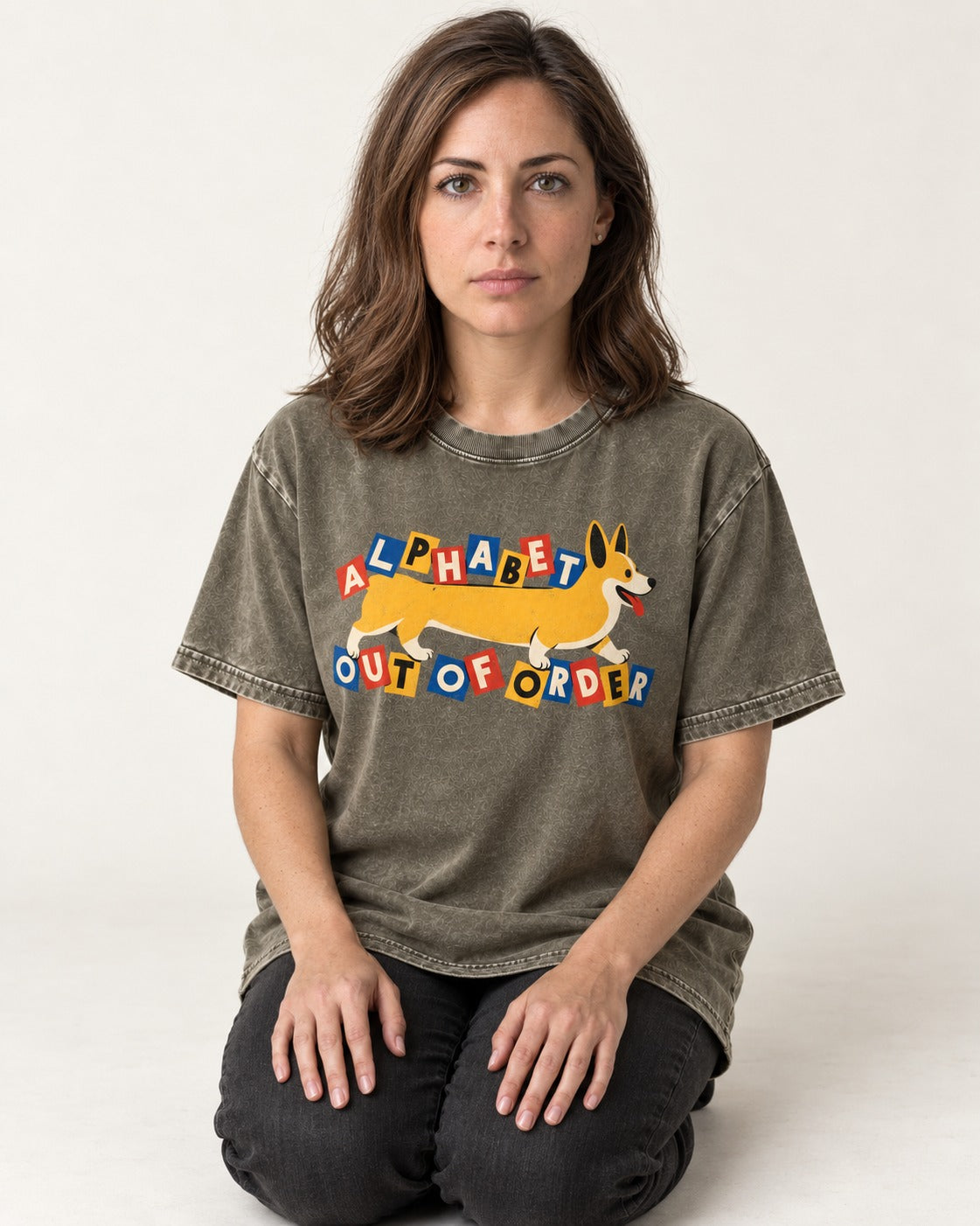 Corgi Alphabet Out of Order Graphic Washed Tee in Army Green, worn by a seated model