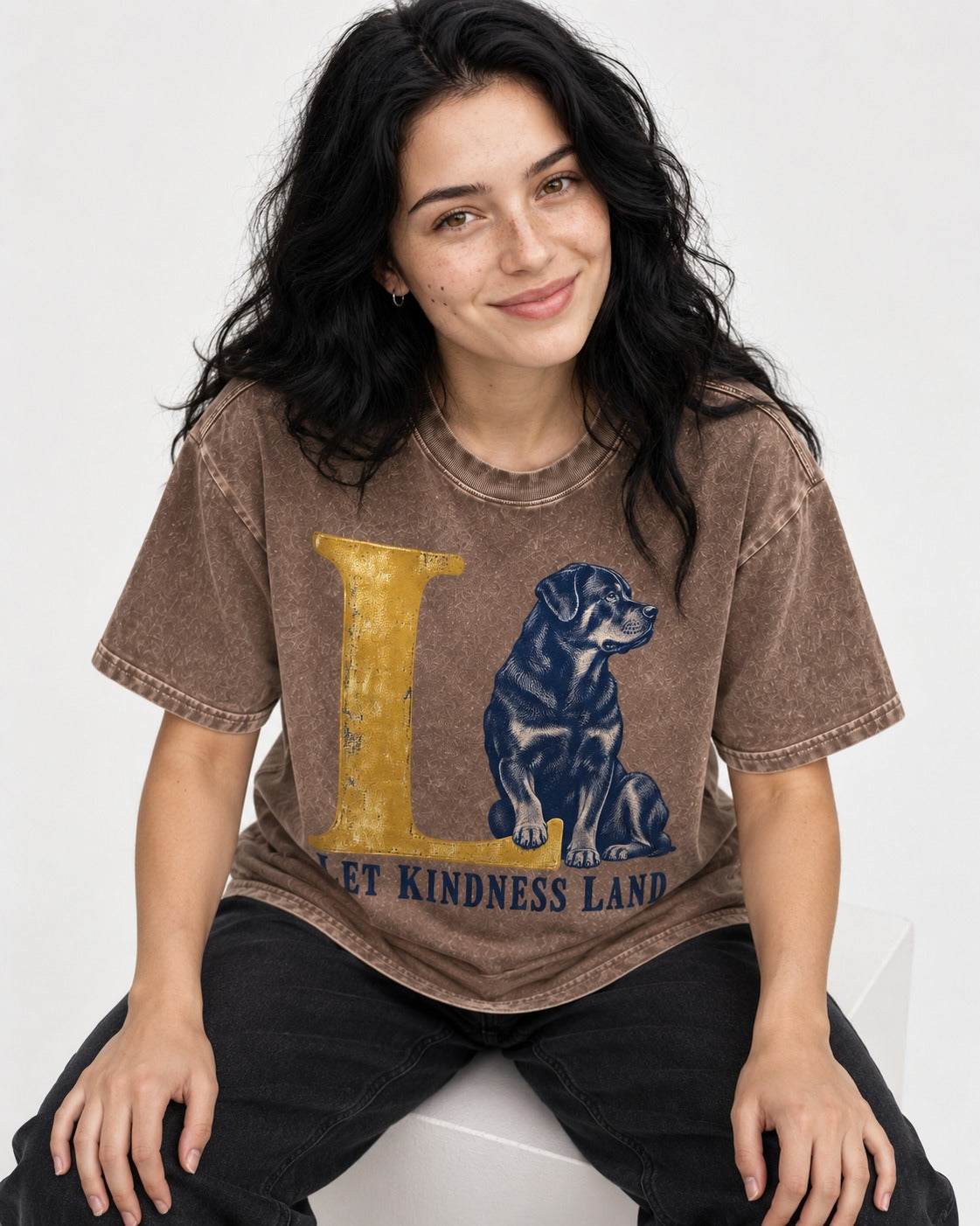 Let Kindness Lead Rottweiler Washed Tee in Coffee, worn by a seated model